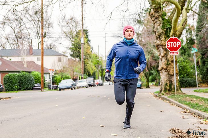 Man running in winter while wearing a Fitbit