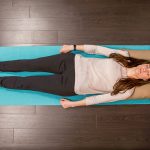 Woman doing progressive muscle relaxation on a yoga mat
