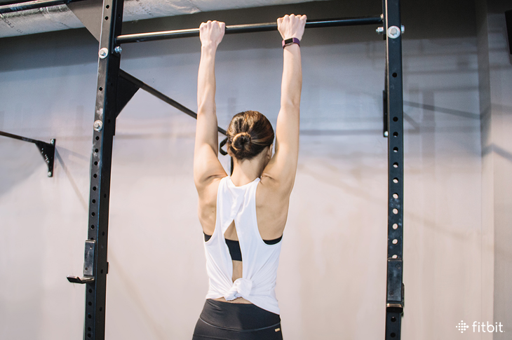 woman doing pull-ups in the gym