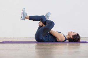 Woman doing a figure-four stretch.