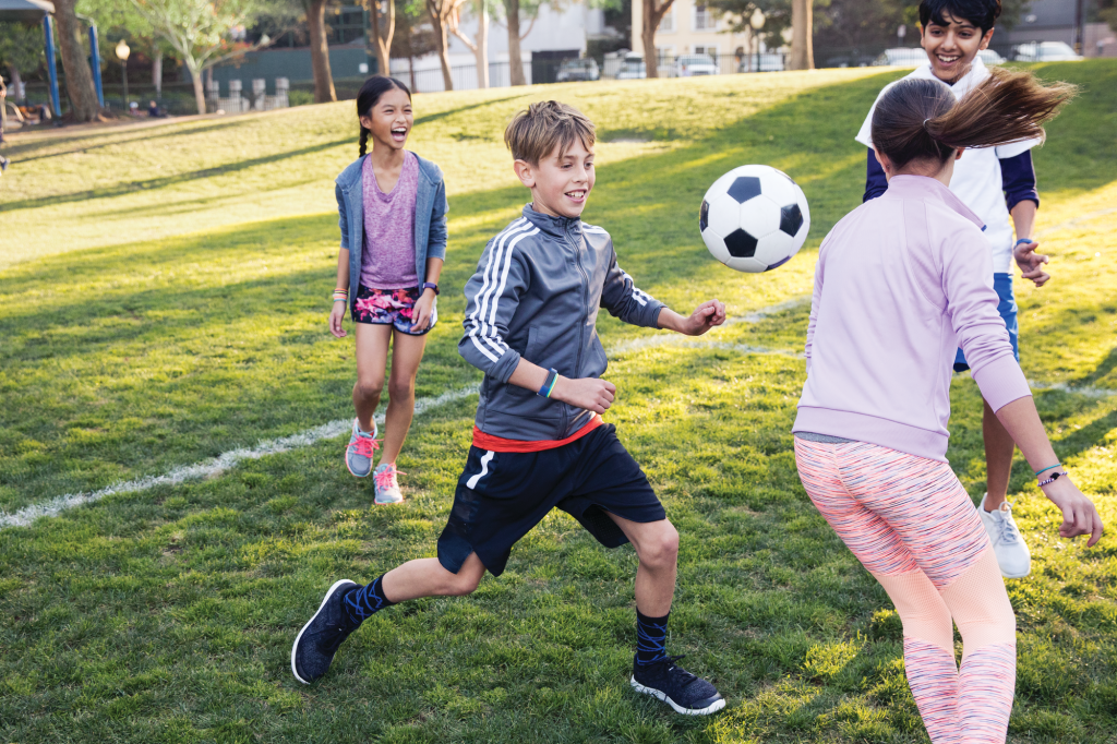 Kids playing soccer while wearing Fitbit Ace